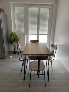 einen Tisch und Stühle in einem Zimmer mit Fenstern in der Unterkunft Appartement près de La défense in Nanterre