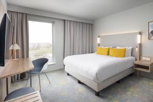 A bed or beds in a room at Courtyard by Marriott Paris Charles de Gaulle Central Airport