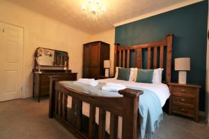 a bedroom with a large wooden bed and a mirror at Signature - Bruce Terrace Lower in High Blantyre