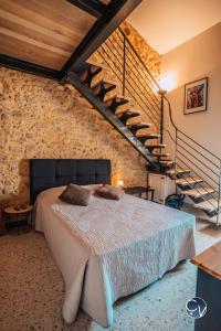 ein Schlafzimmer mit einem Bett und einer Steinmauer in der Unterkunft Agréable maison de village avec terrasse in Pougnadoresse
