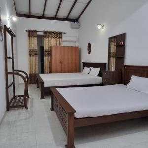 Zimmer mit 2 Betten und einem Stuhl in der Unterkunft White Win Villa in Elewala