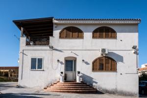 un edificio blanco con persianas marrones y una puerta en Un posto al sole - Caltanissetta, en Caltanissetta