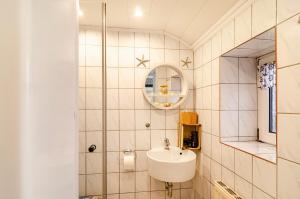 a bathroom with a sink and a mirror at Ferienhaus Segelboot in Krummhörn +14 photos