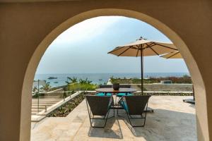 patio z parasolem, stołem i krzesłami w obiekcie Drymades Inn Resort w mieście Dhërmi