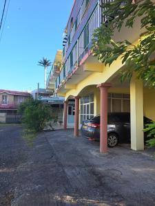 un coche aparcado frente a un edificio en Bano Tourist Residence - 650 meters from Grand Bay Beach, en Grand Baie