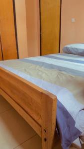 a close up of a wooden bed in a room at Hostelito Room in Kigali