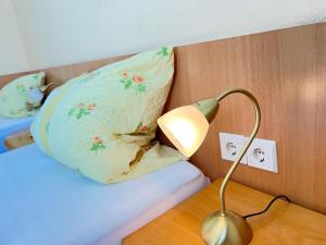eine Lampe auf einem Tisch neben einem Bett mit Kissen in der Unterkunft TM Hotel Westfalen in Lünen