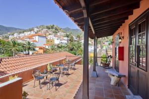 um pátio com mesas e cadeiras num edifício em Tamahuche Hotel Rural em Vallehermoso