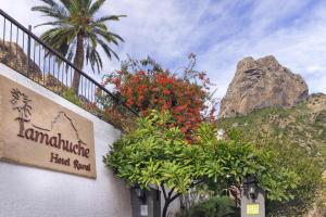 a sign on the side of a building with flowers at Tamahuche Hotel Rural in Vallehermoso