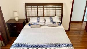 a bedroom with a large bed with a wooden headboard at White Castle villa in Pereybere