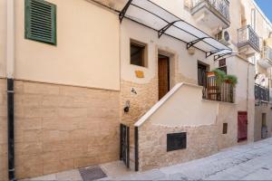 a narrow alley with a building and a staircase at Dimora Donna Lucrezia in Mola di Bari