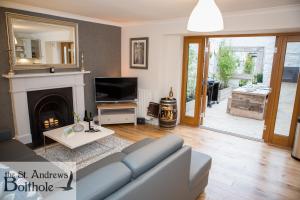 a living room with a couch and a fireplace at Luxury in the most convenient location in St Andrews in St. Andrews