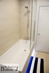 La salle de bains est pourvue d'une douche et d'une baignoire. dans l'établissement Luxury in the most convenient location in St Andrews, à St Andrews