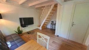 a living room with a couch and a television at פינה בגינה יזרעאלי in ‘Amir