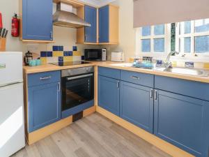 a kitchen with blue cabinets and a sink at The Station Flat in Newlyn East