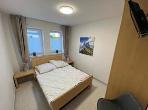 ein kleines Schlafzimmer mit einem Bett und einem Stuhl in der Unterkunft Alpen Appartement Winterberg in Winterberg