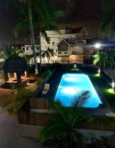 a swimming pool in front of a house at night at White Castle villa in Pereybere