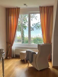een woonkamer met een groot raam en een stoel bij Dünenhaus 2 Schlafzimmer in Timmendorfer Strand