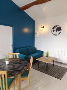 Domaine Moulin D' Elemiah في Gémozac: غرفة معيشة مع طاولة وأريكة زرقاء