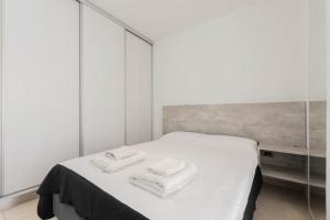 ブエノスアイレスにあるLumimoso departamento en Buenos Aires 1 dormのベッドルーム1室(ベッド1台、タオル2枚付)