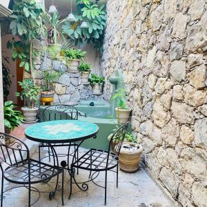 a patio with a table and chairs and a stone wall at Hotel Antigua Casa de Piedra in San Miguel de Allende