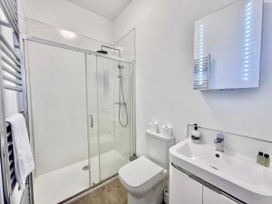 e bagno bianco con doccia, servizi igienici e lavandino. di Cliffords Reach at Bluebridge Court -City Centre - Free Parking a York