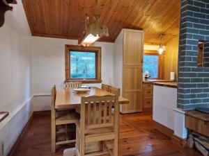a dining room with a wooden table and chairs at Charmig stuga mitt i naturen! in Upplands-Väsby