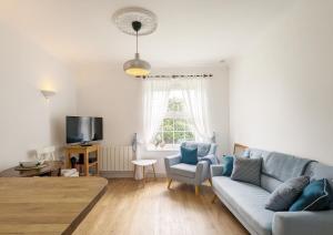 a living room with a couch and a tv at Emsdale House in Emsworth