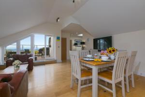 Un comedor y una sala de estar con mesa y sillas. en 7 Sandy Lane, en St Ives