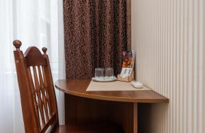 una mesa en una habitación con una silla junto a una cortina en Mini-Hotel Guest Residence en Kiev