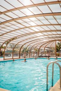 a swimming pool with people in the water at Les Maritimes in Seignosse