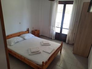 a bedroom with a bed with two towels on it at koula's apartments in Vasiliká