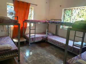 a room with three bunk beds and two windows at NamahStay Hostel, Cowork & Artist residency Arambol in Arambol