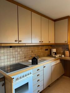 a kitchen with white cabinets and a stove top oven at Naturparadies Nähe Grüner See 