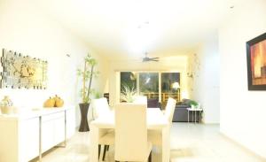 a kitchen and dining room with white furniture at BLUE OCEAN RIVIERA MAYA in Playa del Carmen