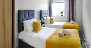 1 dormitorio con 2 camas con sábanas blancas y amarillas en Cambridge Stays Riverside 1BR Flat-Walk to Centre-Parking, en Cambridge