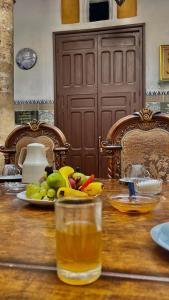 a table with a glass of beer and a plate of fruit at Riad Le Palais in Rabat