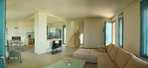 a large living room with a couch and a kitchen at Ouzo Panoramic Houses 1, with private pool in Plomari