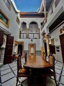 comedor con mesa de madera y sillas en Riad Le Palais en Rabat