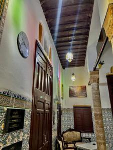 una habitación con un reloj en la pared y una puerta en Riad Le Palais en Rabat
