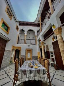 a table and chairs in a courtyard with a building at Riad Le Palais in Rabat