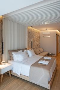 1 dormitorio con 1 cama blanca grande y 1 sofá en THERETRA PEFKI Seaside en Pefki Rhodes