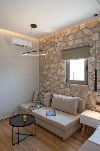 un soggiorno con divano e parete in pietra di THERETRA PEFKI Seaside a Pefki Rhodes