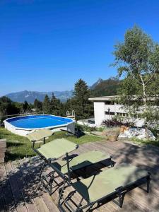 a couple of patio chairs and a swimming pool at Chalet du Moléson in Gruyères