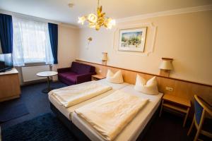 um quarto de hotel com uma cama e uma cadeira roxa em Gasthof zur Länd em Moosburg