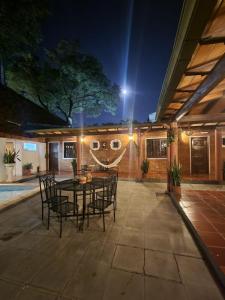 a patio with a table and chairs at night at Hotel Hassler in Asunción