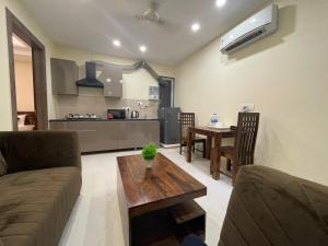 een woonkamer met een bank en een tafel bij LIMEWOOD STAY SERVICE Apartment ARTEMIS HOSPITAL in Gurgaon