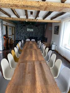długi stół w pokoju z białymi krzesłami w obiekcie Вила Дружинци 
