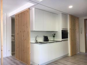 una cocina con armarios blancos y un aparato negro en Apartamento Castro Celta, en Vigo