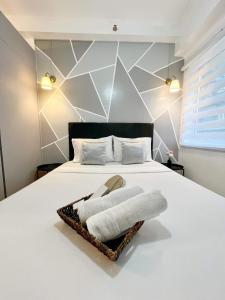 - une chambre avec un lit et des serviettes dans l'établissement JA2 STAYCATION @TREES RESIDENCES, à Manille